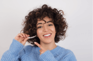 Arab woman holding an invisible aligner braces