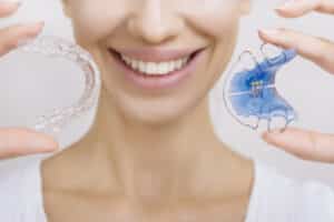 Smiling girl Holding Retainer for Teeth and Tooth Tray