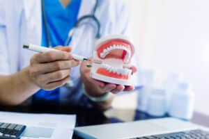 An orthodontist holding a model of the jaw and explaining orthognathic surgery