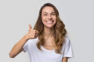 A woman smiling and showing the results of Invisalign® in Denver