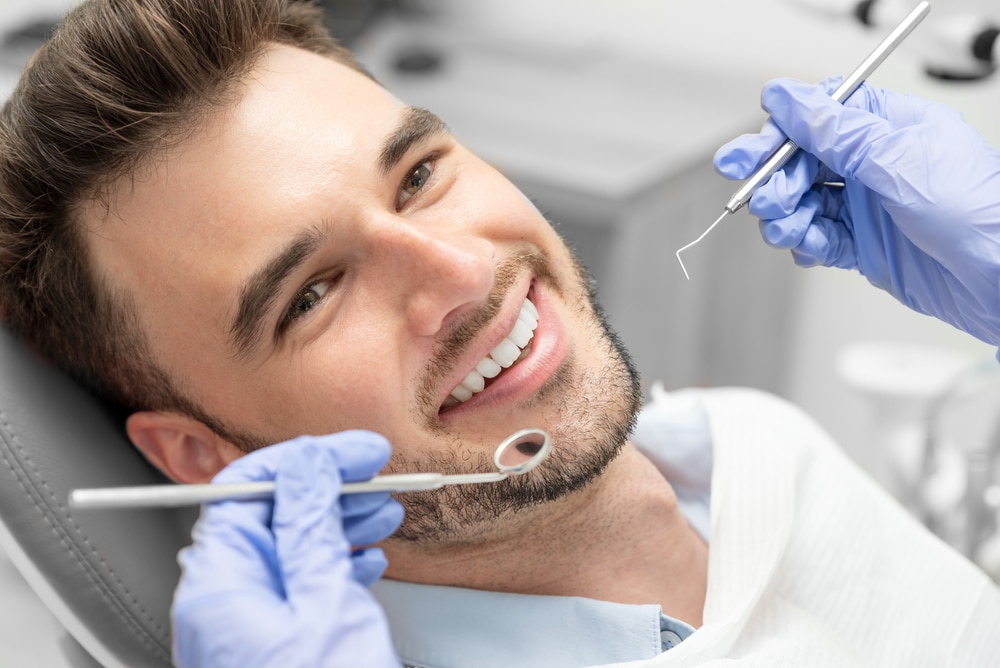 A close-up shot of a man with straight teeth getting dental work done