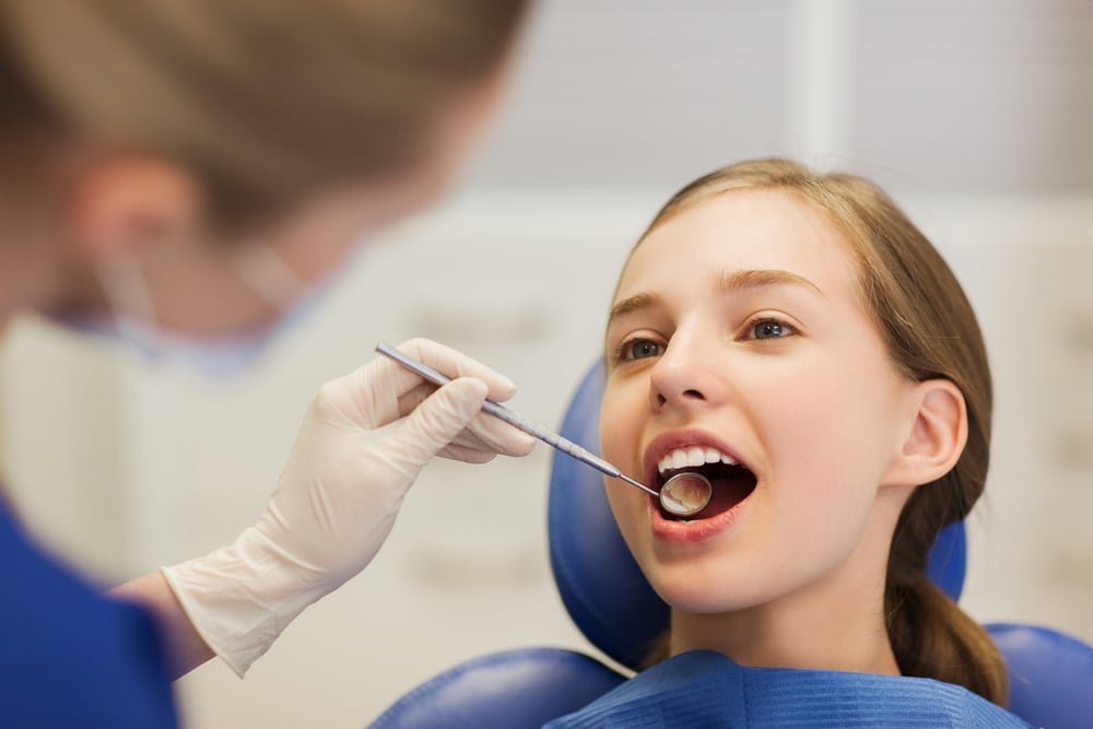 Teen receiving an orthodontic exam, representing what happens during a first orthodontic consultation.