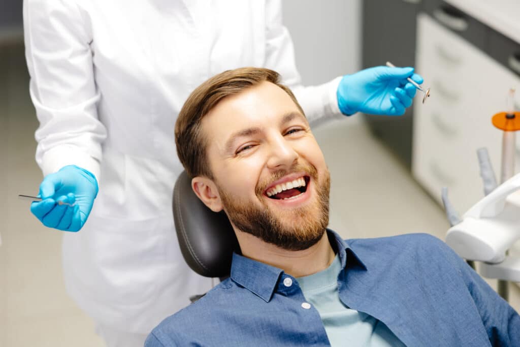 Smiling adult patient during an orthodontic exam focused on bite alignment and oral health.